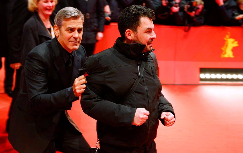 US actor George Clooney jokes with a photographer as he arrives at the red carpet for 'Hail, Caesar!' the opening film of the 2016 Berlinale Film Festival in Berlin, Germany.