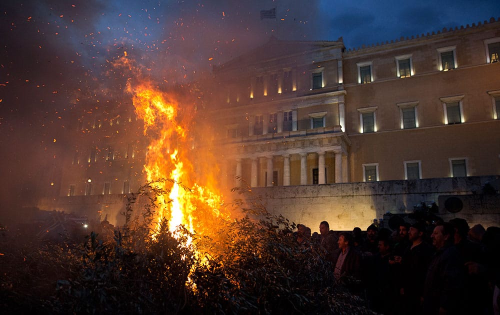 Farmers burn olive branches in front of the Greek parliament during a protest in Athens.
