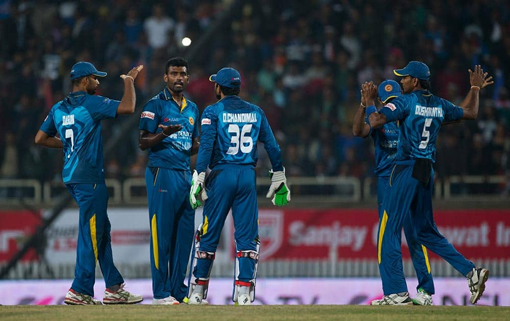 Sri Lankan bowler Thisara Perera, second left, who claimed a hat-trick against India, celebrates with teammates after claiming an Indian wicket during the second T20 match of a three match series between the two countries, in Ranchi.