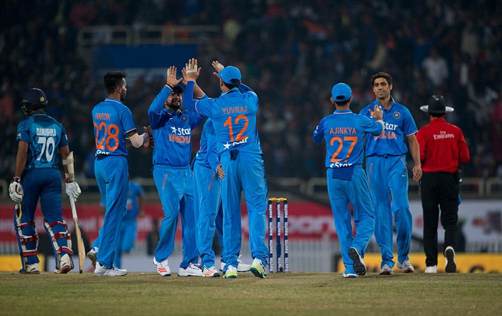 Cricketers celebrate the fall of Sri Lankan batsman Seekkuge Prasanna during the second T20 match of a three match series between the two countries, in Ranchi.