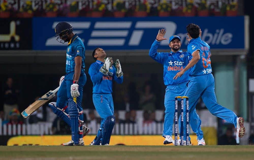 Ashish Nehra, Suresh Raina and Mahendra Singh Dhoni, celebrate the fall of Sri Lankan batsman Danushka Gunathilaka, left, during the second T20 match of a three match series between the two countries, in Ranchi.