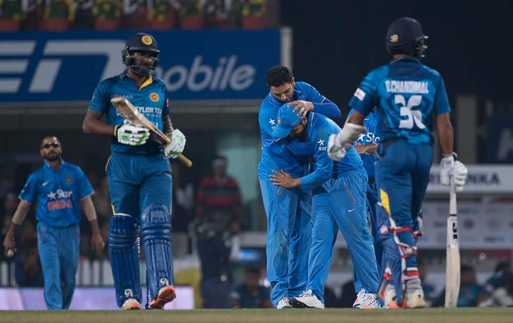 Bowler Yuvraj Singh, congratulates teammate Rohit Sharma, second right, after Sharma dived to take a catch which was later not given out after replays showed that the ball had bounced, against Sri Lanka during the second T20 match of a three match series between the two countries, in Ranchi.