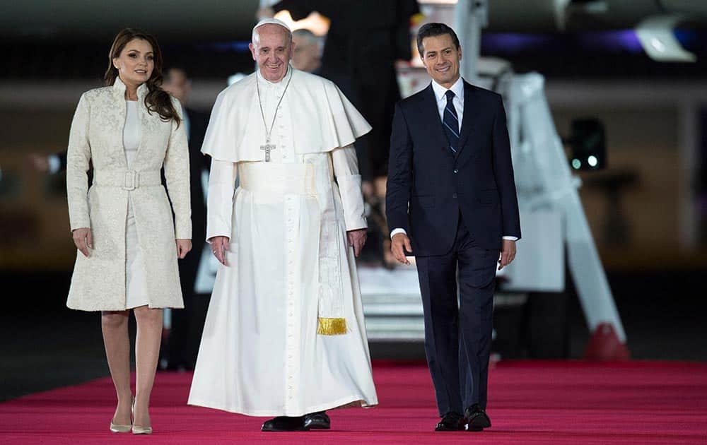 Pope Francis poses with Mexico's President Enrique Pena Nieto, right, and first lady Angelica Rivera upon his arrival to the Benito Juarez International Airport in Mexico City..