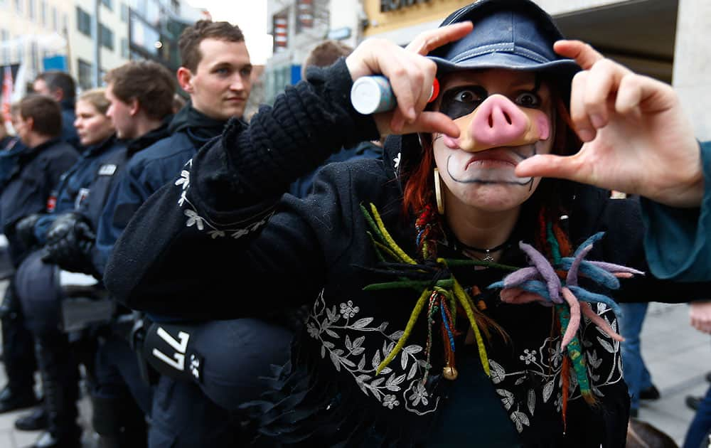 A protester reacts while being photographed during a demonstration against the Security Conference in Munich, Germany.