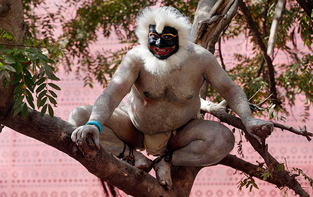 An Indian artist dressed as a langur entertains delegates visiting 'Make in India' centre in Mumbai.