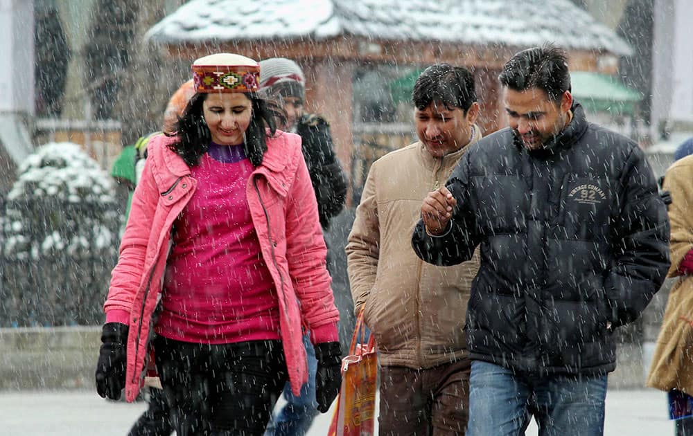 People walking on ridge during heavy snowfall in Shimla.
