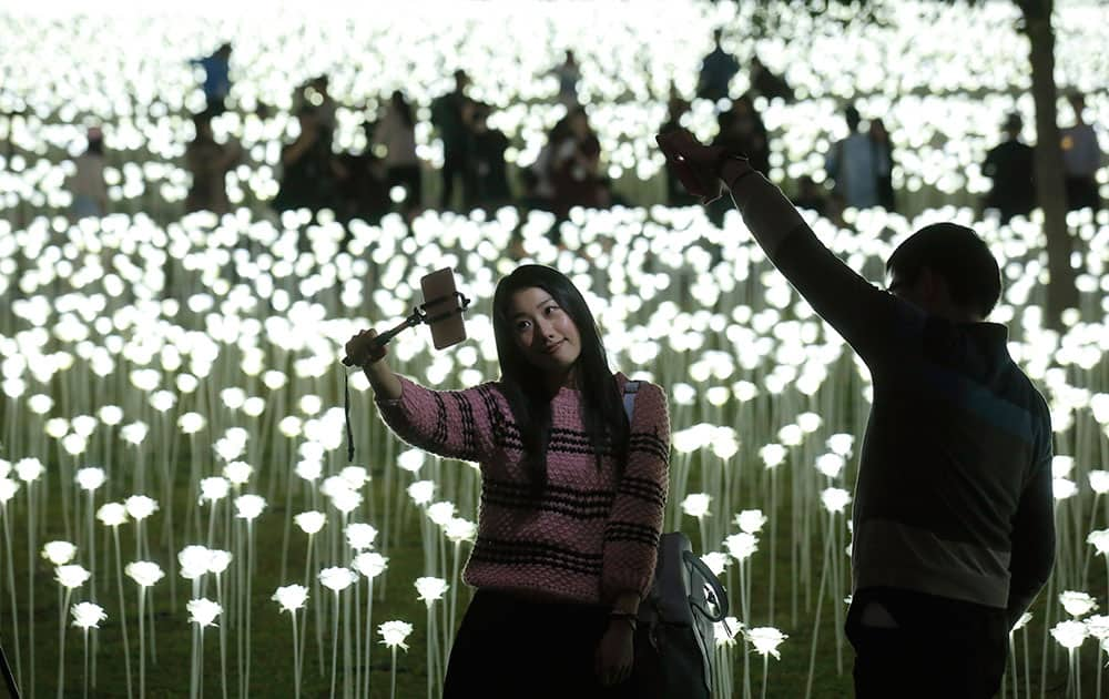 A woman takes a selfie in front of the LED lights roses at the “Light Rose Garden” in Hong Kong.