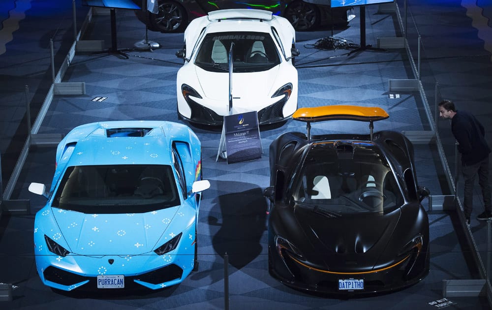 A man looks over vehicles at the 2016 Canadian International Autoshow in Toronto on Thursday, Feb. 11, 2016. 