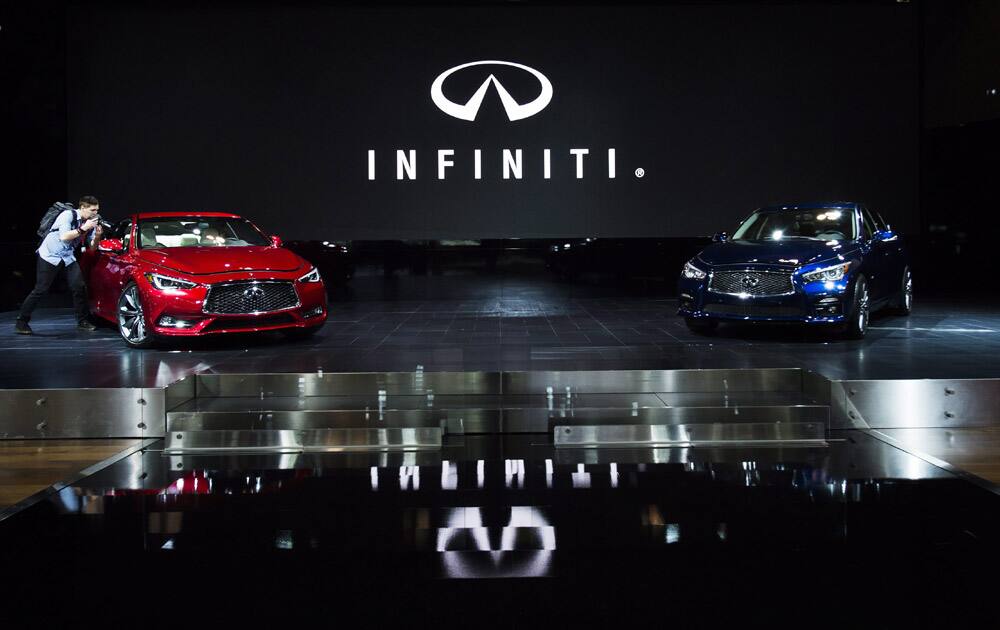 A man photographs a car at the Infiniti booth at the 2016 Canadian International Autoshow in Toronto on Thursday, Feb. 11, 2016. 