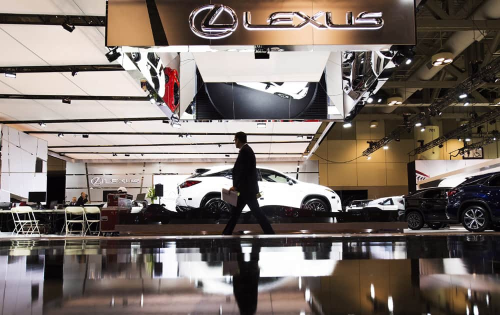 A man walks by the Lexus booth at the 2016 Canadian International Autoshow in Toronto on Thursday, Feb. 11, 2016. 