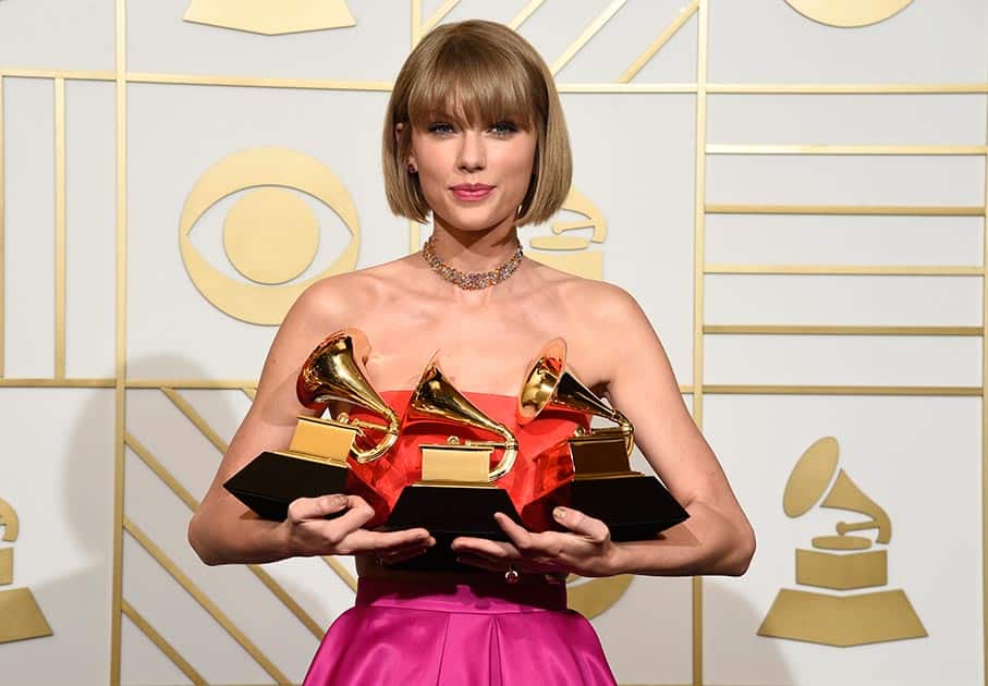 Taylor Swift poses in the press room with the awards for album of the year for 1989, pop vocal album for 1989 and best music video for 'Bad Blood' at the 58th annual Grammy Awards at the Staples Center, in Los Angeles.