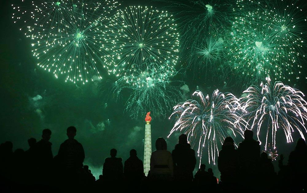 North Koreans watch from the Kim Il Sung Square as fireworks explode over the Juche Tower during celebrations of the 'Day of the Shining Star' or birthday anniversary of late North Korean leader Kim Jong Il, in Pyongyang, North Korea.