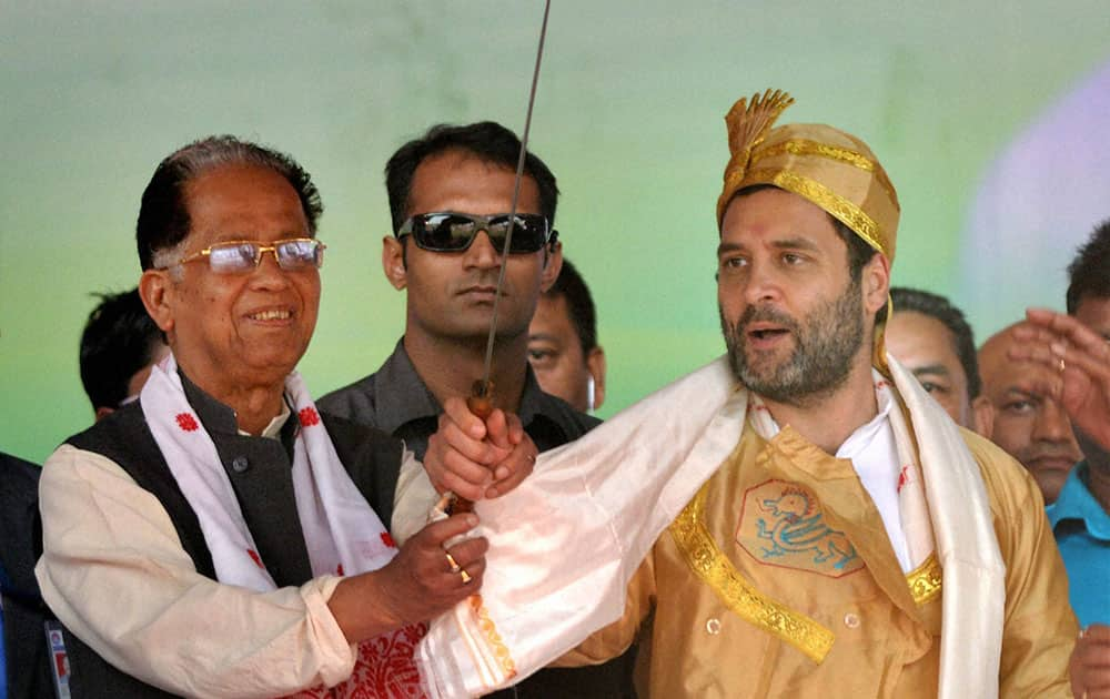 Congress Vice President Rahul Gandhi being felicitated with Ahom tribes traditional dresses and a sword during the partys Jana Jagaran Samaroh in Sivasagar, Assam.
