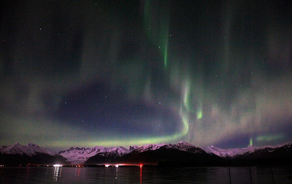 An active aurora borealis hovers over downtown Juneau and the Mendenhall glacier, in Juneau, Alaska.