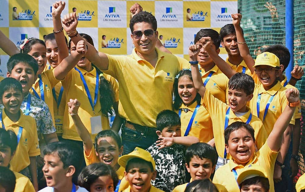 Cricket legend Sachin Tendulkar with kids during a promotional event of Aviva Life Insurance in Mumbai.