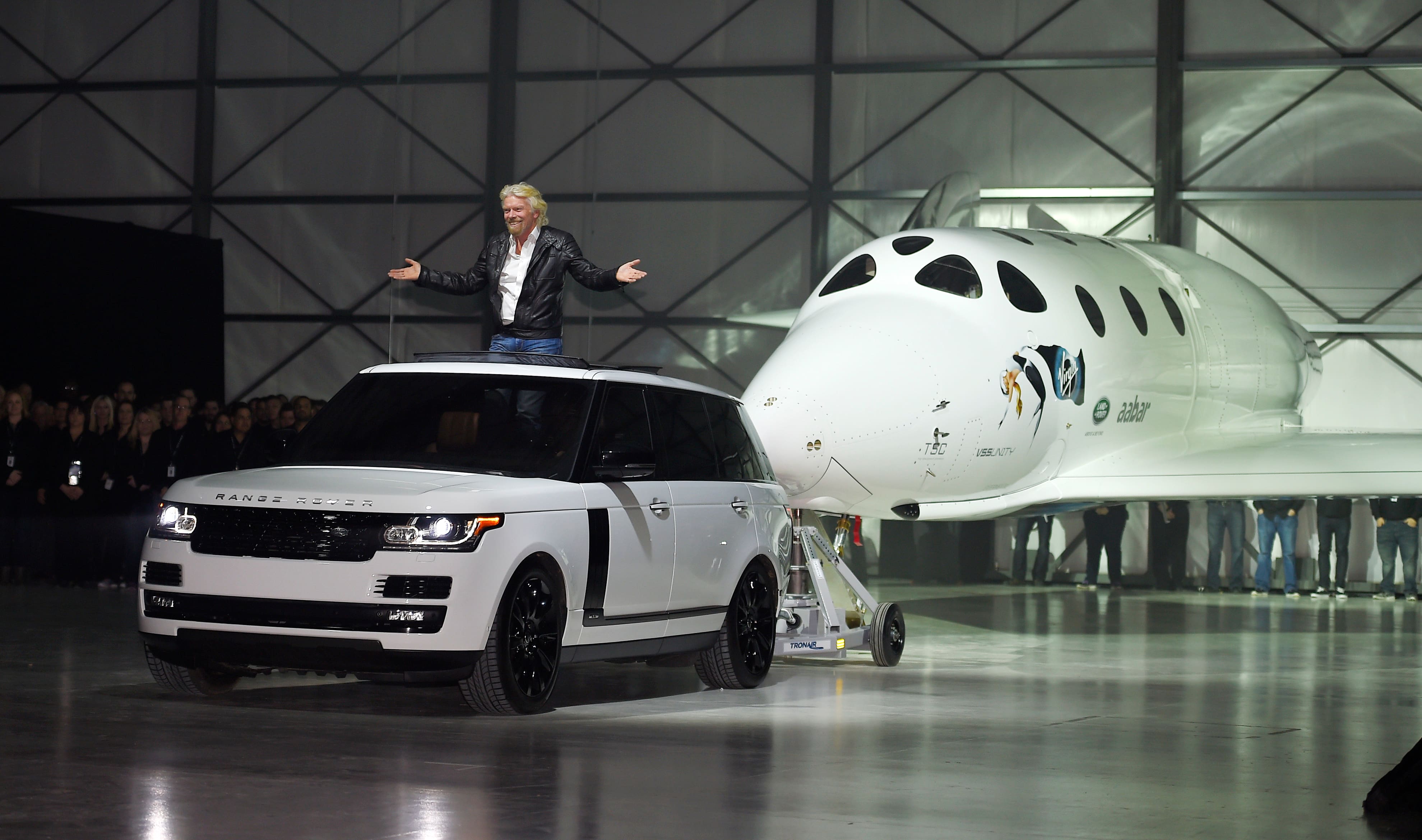 Sir Richard Branson leads Virgin Galactic's SpaceShipTwo space tourism rocket as it is rolled out, in Mojave, Calif..