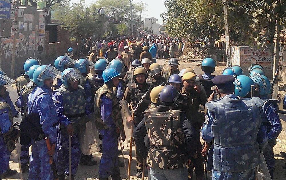 Security forces personnel trying to control Jat protesters at Ladsauli village during their agitation for reservation, at GT Road near Sonipat.
