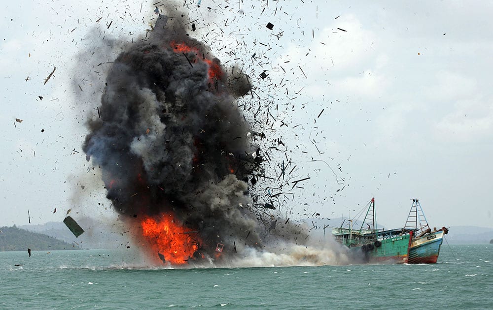 Debris fly into the air as foreign fishing boats are blown up by Indonesian Navy off Batam Island, Indonesia.
