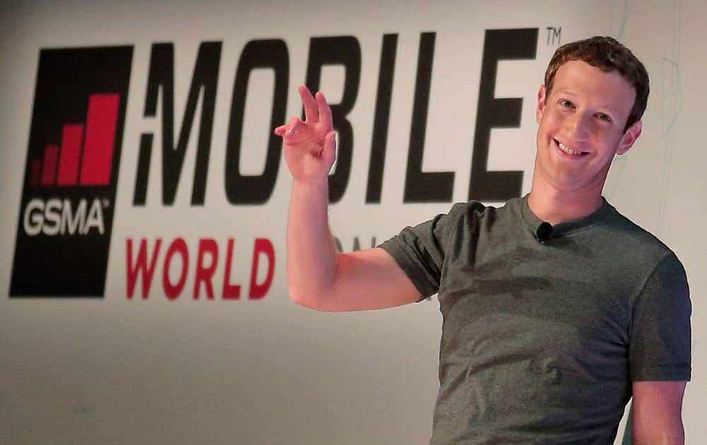 Facebook CEO Mark Zuckerberg waves to the audience as he arrives for a conference at the Mobile World Congress wireless show in Barcelona.