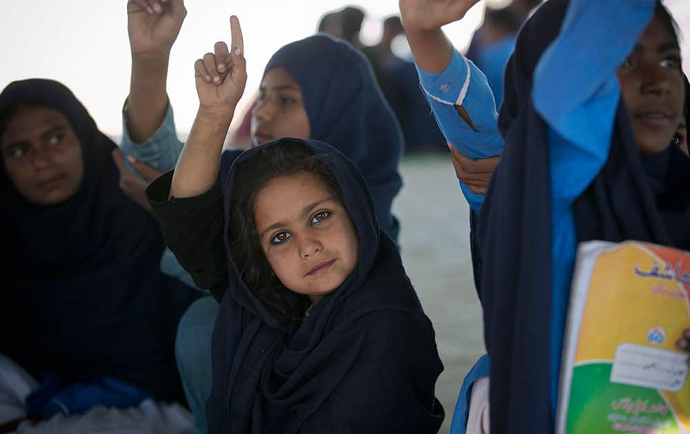 Pakistani students from poor families attend a makeshift school set up by an NGO in Islamabads slums.