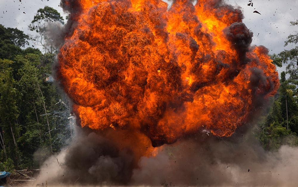 A fire ball rages after police set fire to motorcycles and gasoline at an illegal gold mining camp during a government raid to dismantle it in La Pampa.