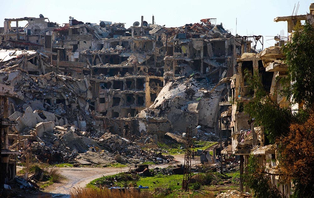 A Syrian man walks through a devastated part of the old city of Homs, Syria.