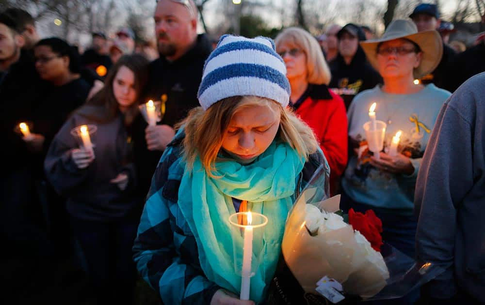 Kelly Slayton takes part in a candlelight vigil at Heritage Park in Hesston, Kan.