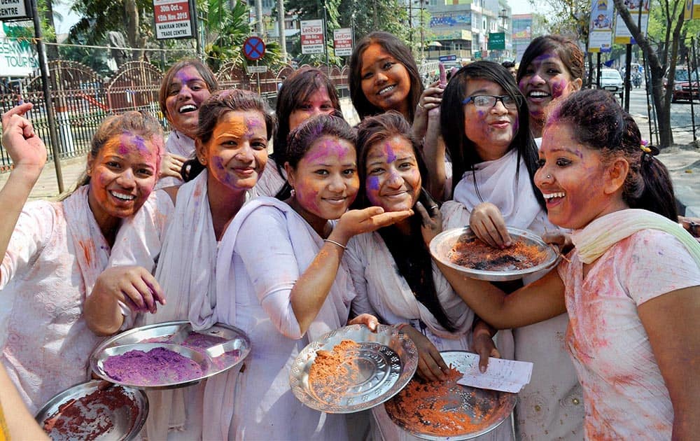 Students of Cotton College State University play Holi at a cultural procession during the University Week celebrations, in Guwahati.