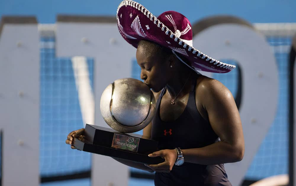 Sloane Stephens, of the United States, wears traditional Mexican headgear as she kisses her trophy after defeating Dominika Cibulkova, of Slovakia, in the WTA final of the Mexican Tennis Open in Acapulco, Mexico.