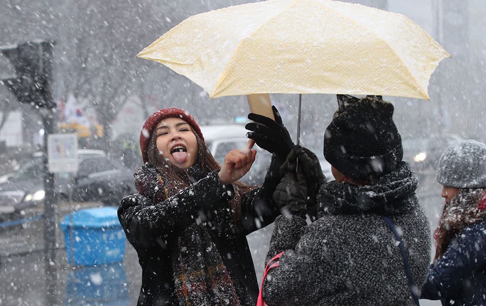 A woman takes a selfie in heavy snow in Seoul, South Korea.