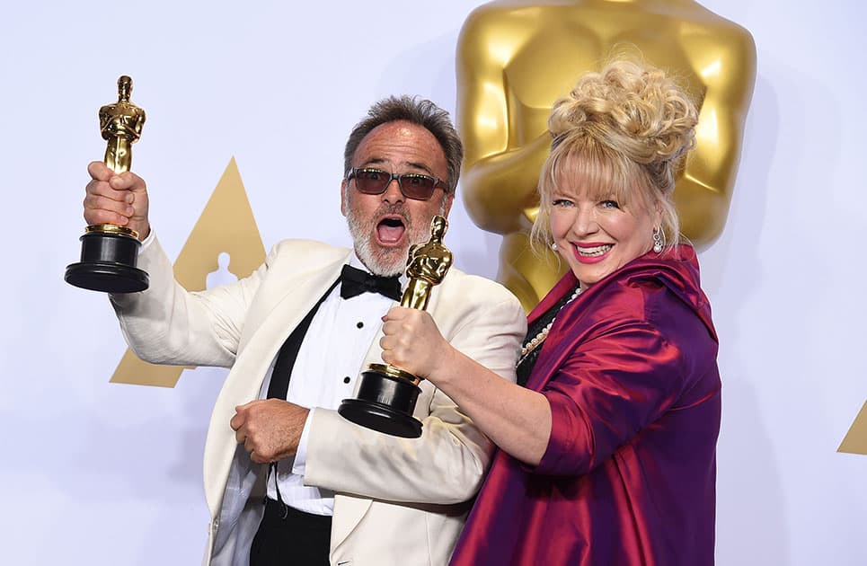 Colin Gibson and Lisa Thompson pose with the award for best production design for “Mad Max: Fury Road” in the press room at the Oscars at the Dolby Theatre in Los Angeles.