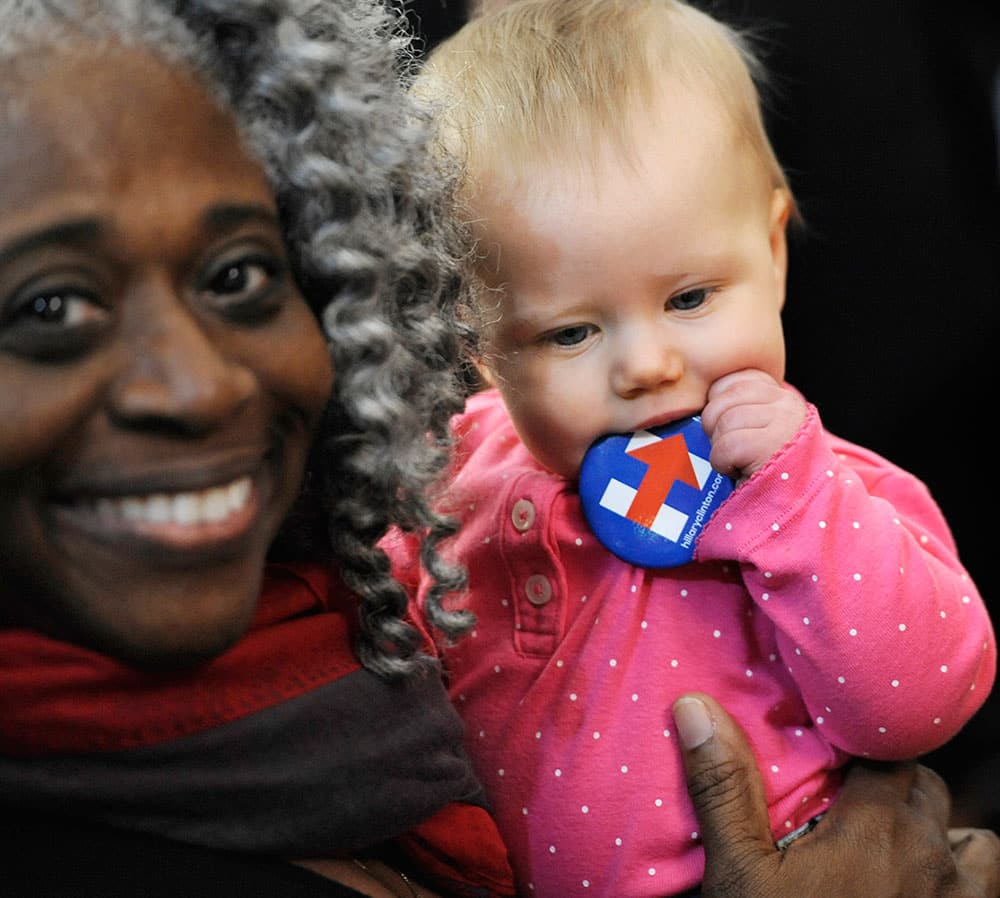 Candi Fetzer of Orange, Mass., holds nine-month-old Elanor Perkins of Turners Falls, Mass., as Perkins teeths on a button for Democratic presidential candidate Hillary Clinton at a campaign event for Clinton in Springfield, Mass.