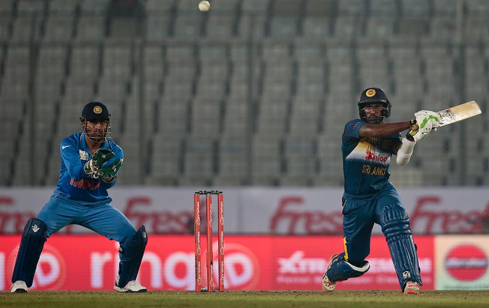 Chamara Kapugedera plays a shot, as Mahendra Dhoni follows the ball during their Asia Cup Twenty20 international cricket match in Dhaka, Bangladesh.