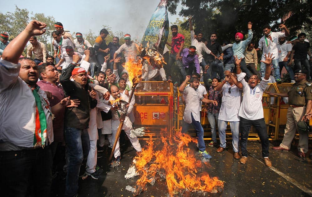 Supporters of the youth wing of India’s opposition Congress Party burn the effigy of Human Resource Development Minister Smriti Irani during a protest in New Delhi.