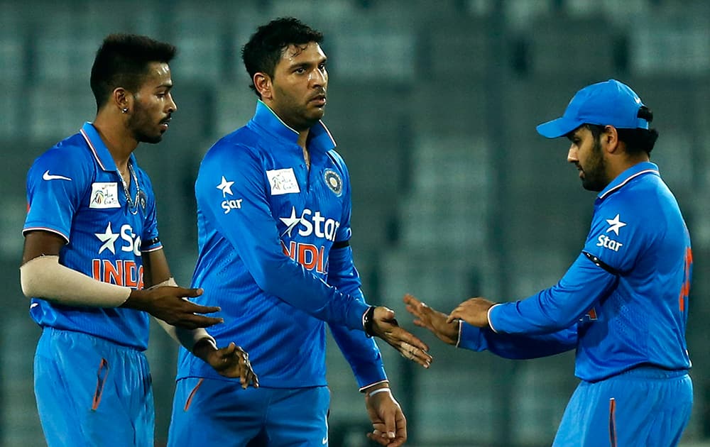Yuvraj Singh, celebrates with his teammates Hardik Pandya, left, and Rohit Sharma after the dismissal of United Arab Emirates’ Muhammad Kaleem during the Asia Cup Twenty20 international cricket match between them in Dhaka.