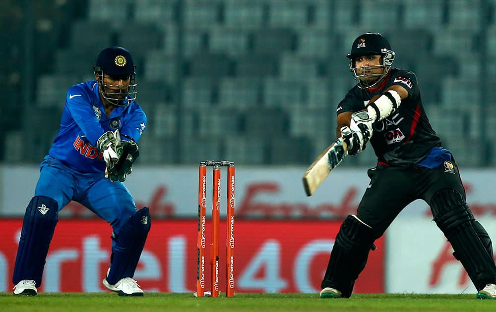 United Arab Emirates’ Shaiman Anwar, right, plays a shot, as India's captain Mahendra Dhoni follows the ball during the Asia Cup Twenty20 international cricket in Dhaka.