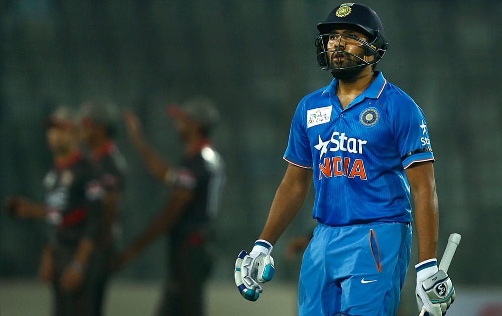 Rohit Sharma, right, walks back to pavilion after his dismissal by United Arab Emirates’ Qadeer Ahmed during the Asia Cup Twenty20 international cricket match in Dhaka.