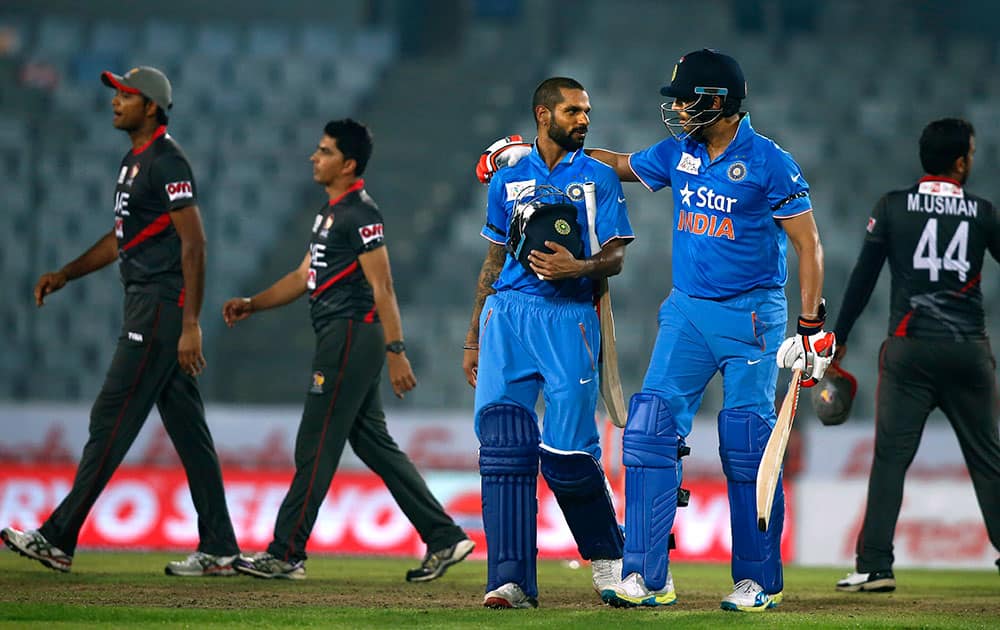 Shikhar Dhawan and Yuvraj Singh, walk out from the field after winning the Asia Cup Twenty20 international cricket match against United Arab Emirates in Dhaka, Bangladesh.