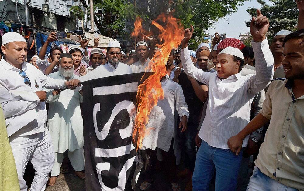 Muslims burn and ISIS flag during a protest in front of Tipu Sultan Mosque in Kolkata.