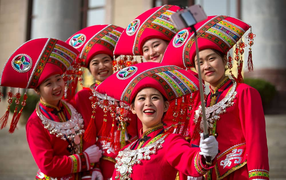 Hostesses, who facilitated the arrival of delegates by bus, pose for a selfie on the steps of the Great Hall of the People during the opening session of China's annual National People's Congress (NPC) in Beijing.