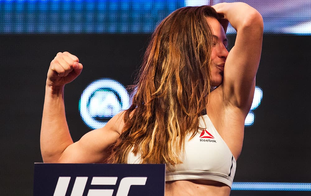UFC women's bantamweight contender Miesha Tate kisses her bicep during the UFC 196 weigh ins at the MGM Grand Garden Arena in Las Vegas.