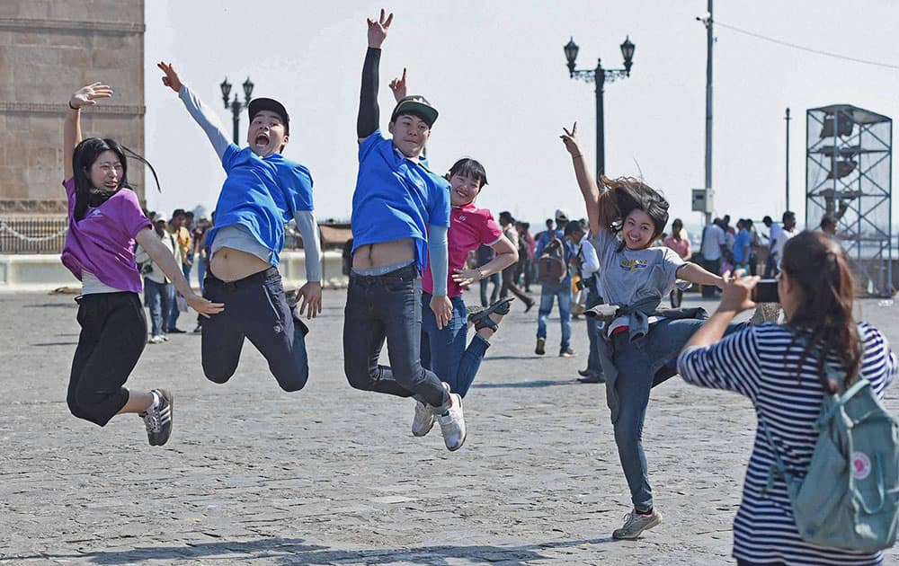 Elated tourists pose for a photograph at the Gateway of India in Mumbai.