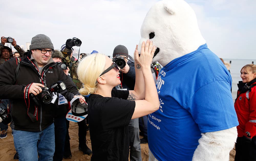 Lady Gaga, center, jokes with the Polar Plunge mascot before Chicago's Polar Plunge at North Avenue Beach in Chicago. 