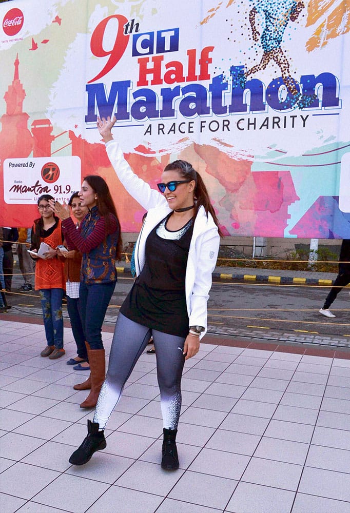 Actress Neha Dhupia waves at 9th CT Half Marathon in Jalandhar.