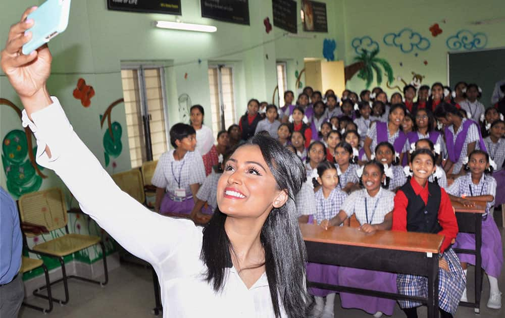 Miss USA 2014 Nina Davuluri takes a selfie with the kids of at a school in Hyderabad.