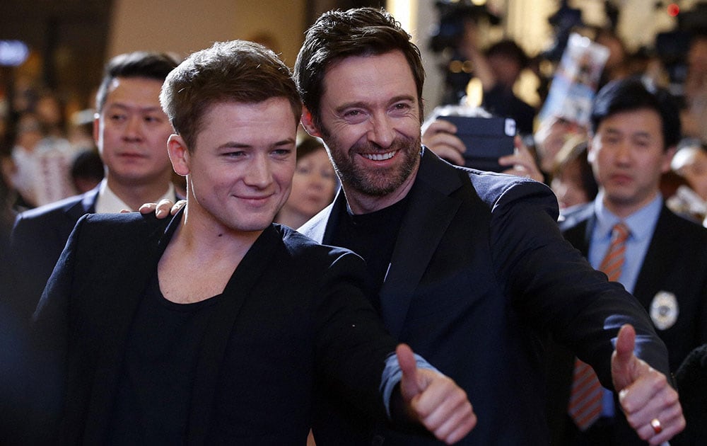 Actors Taron Egerton, left, and Hugh Jackman, right, pose for their fans during a red carpet event to promote their latest movie Eddie The Eagle in Seoul, South Korea.