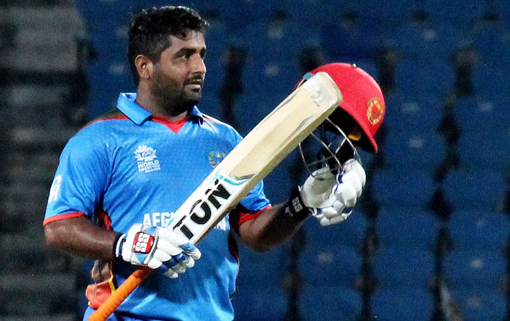 Afghanistan batsman Shahzad Mohammadi lifts his bat afier completing his half century against Scotland during thier ICC T20 World cup match in Nagpur.