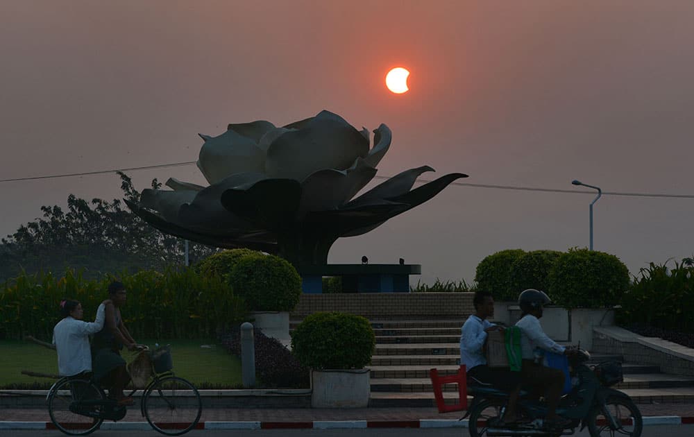 A partial solar eclipse is seen above a traffic circle in capital Naypytaw, Myanmar.