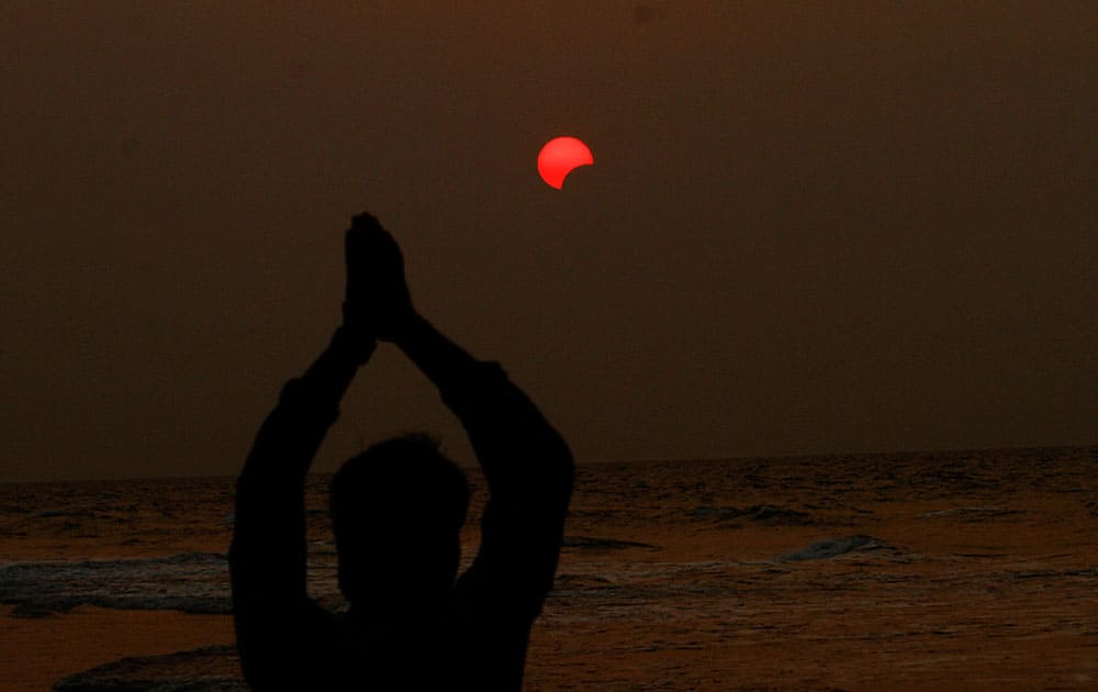 A fisherman prays to a partial solar eclipse seen in the sky over Bay of Bengal in Konark, 60 kilometers (37 miles) from eastern Indian city Bhubaneswar.