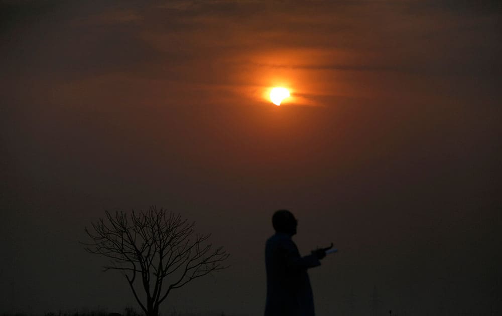 A Bangladeshi man watches a partial solar eclipse in Dhaka, Bangladesh.